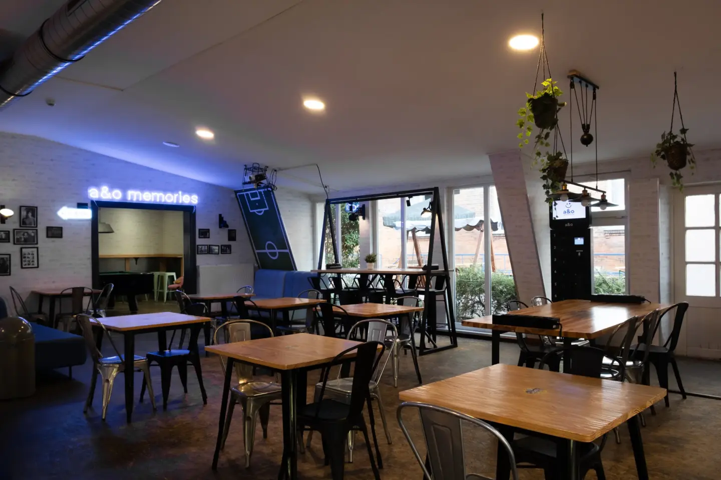 Klassenfahrt Berlin - im a&o Hostel stehen im Aufenthaltsraum Holztische und Stühle