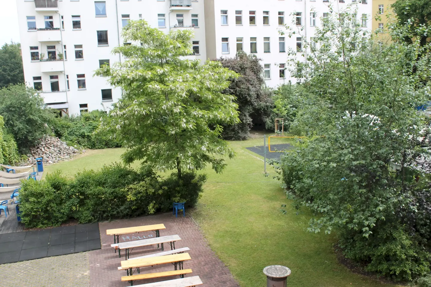 Klassenfahrt Berlin - grüner Garten mit Bäumen, Sträuchern und Volleyballfeld