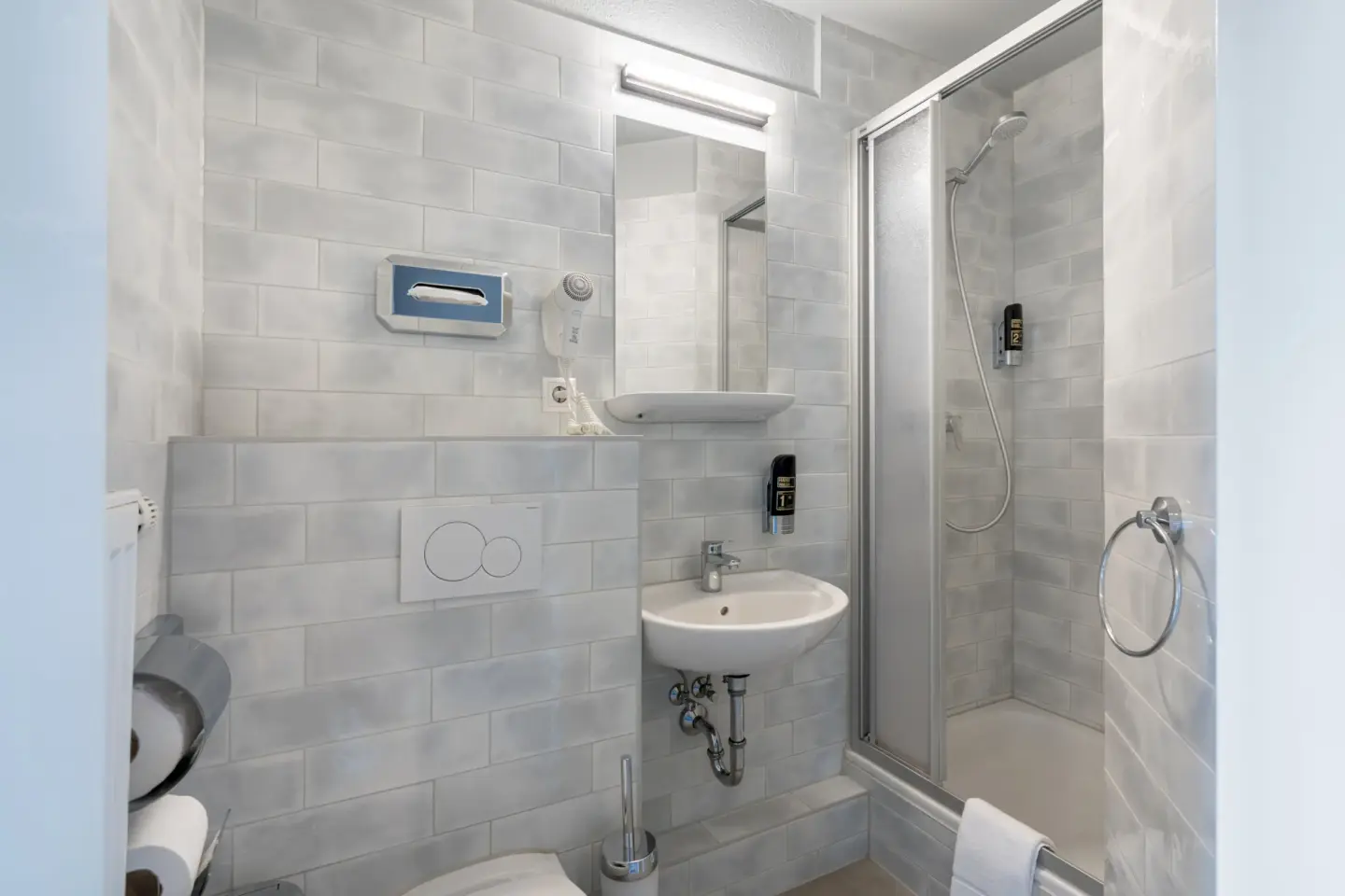Klassenfahrt Berlin - Badezimmer mit hellen Wänden, Dusche und Waschbecken