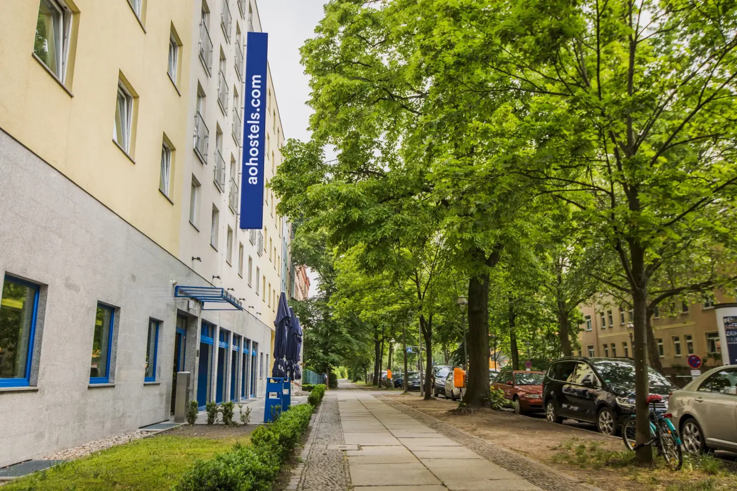 Klassenfahrt Berlin - a&o Hostel neben Fußweg mit großen grünen Bäumen