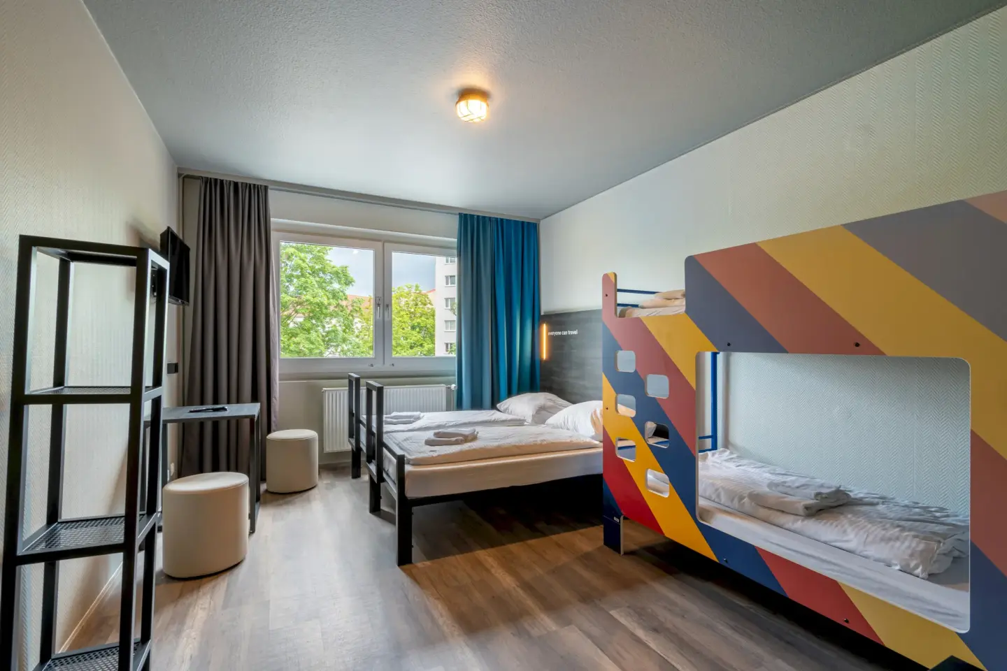 Klassenfahrt Berlin - a&o hostel berlin kolumbus ein buntes Doppelstockbett steht vor einem Doppelbett