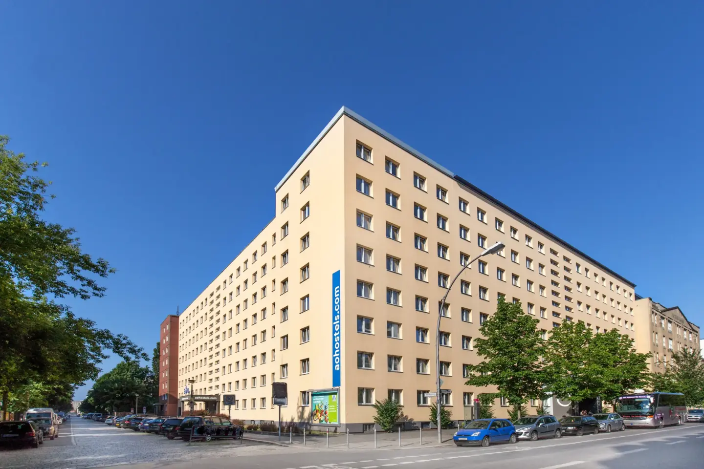 Klassenfahrt Berlin - großes gelbes Eckgebäude an einer Straßenkreuzung unter blauem Himmel