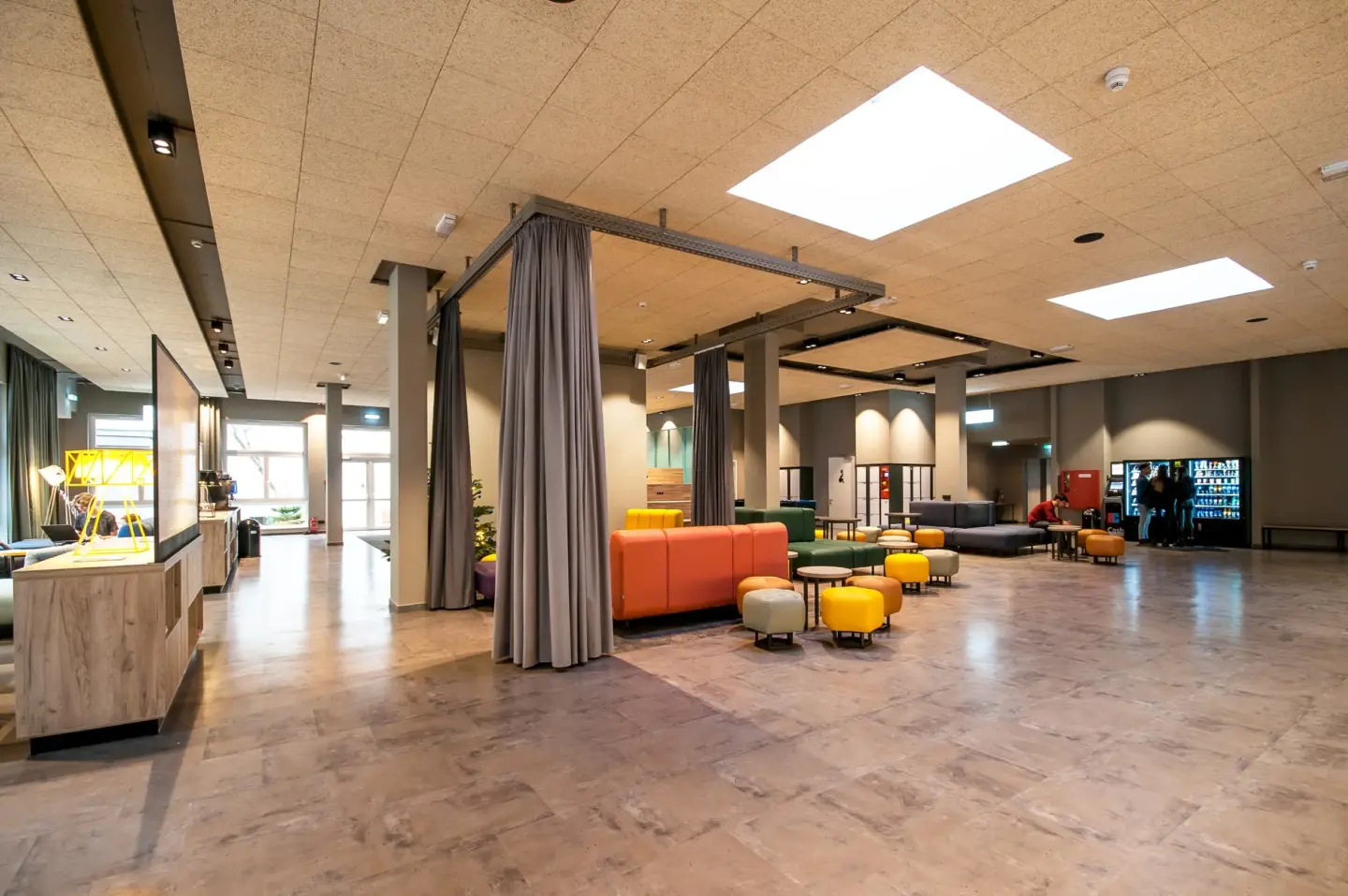 Klassenfahrt Berlin - Aufenthaltsraum mit gemütlichen bunten Sofas, Hockern und Getränkeautomat