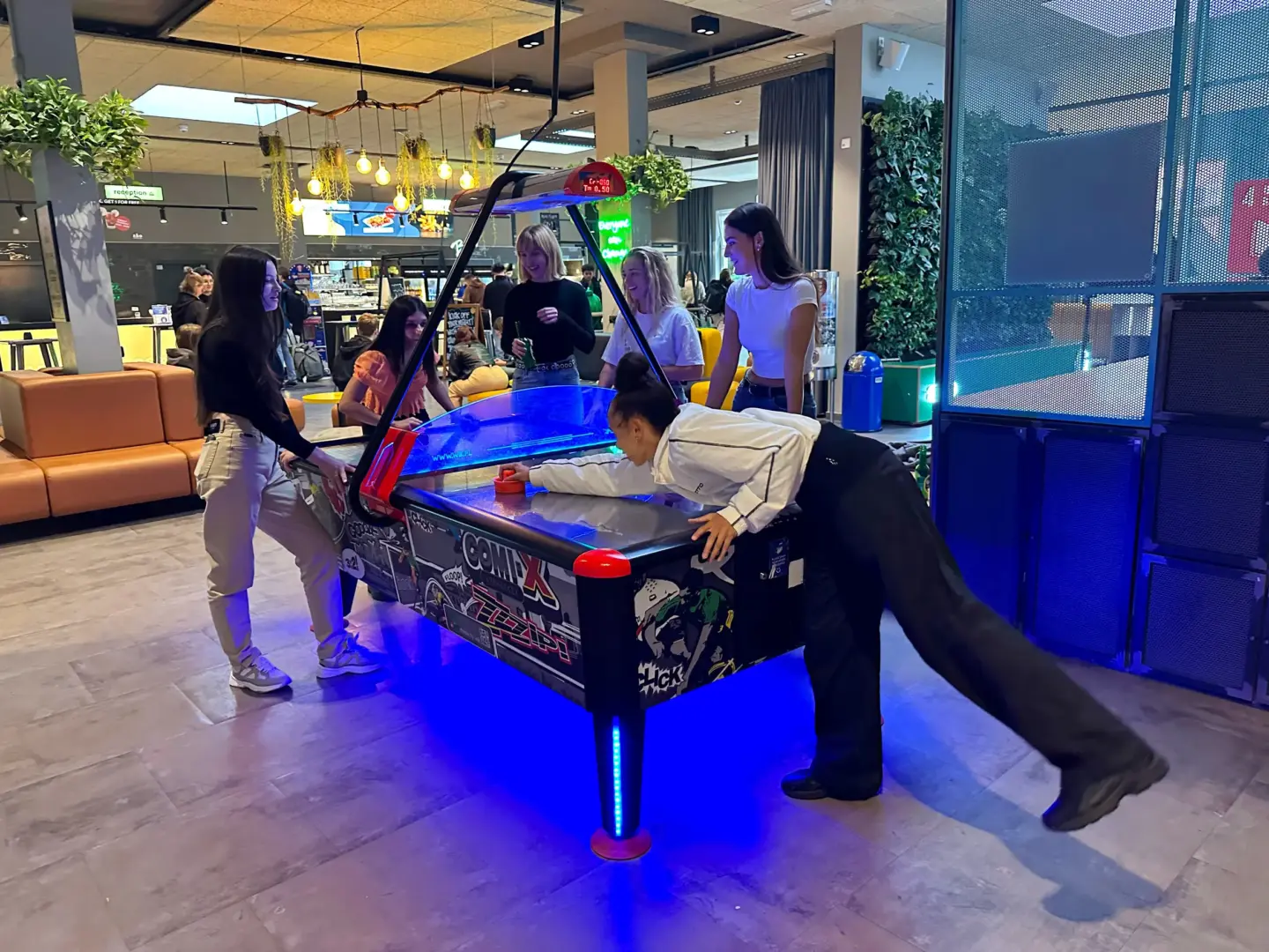 Klassenfahrt Berlin - fröhliche Personen spielen Air Hockey