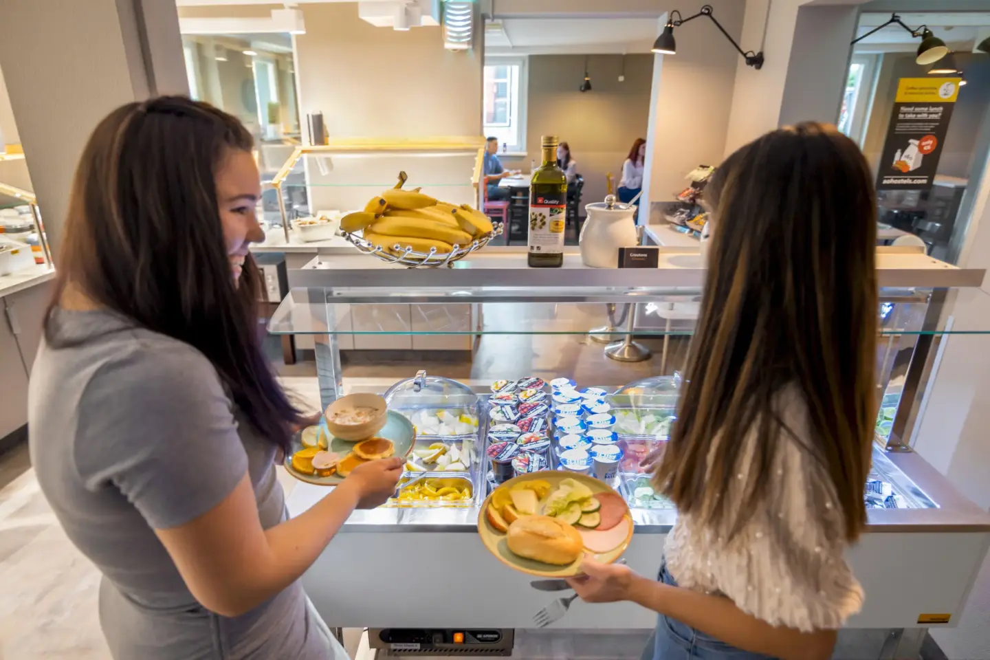 Klassenfahrt Dresden - zwei Mädchen stehen mit vollen Tellern am Frühstücksbuffet