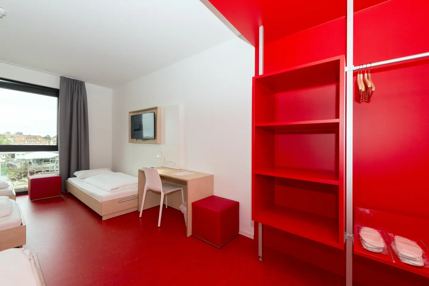 Klassenfahrt Cuxhaven - Mehrbettzimmer mit rotem Fußboden und Schränken