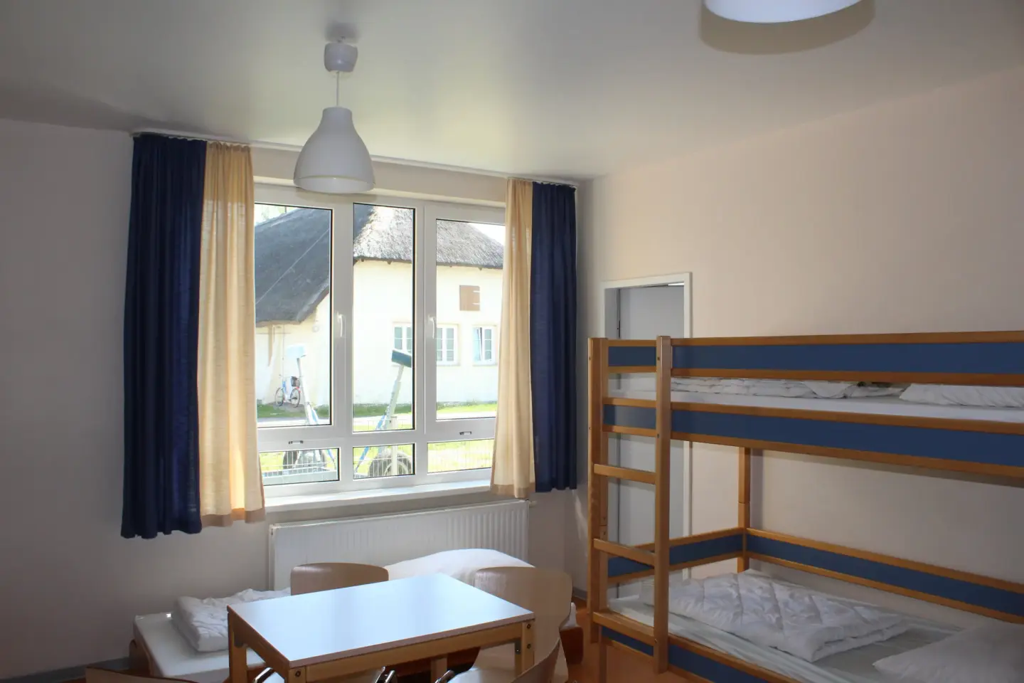 Klassenfahrt Greifswald - Zimmer mit mehreren Betten und großem Fenster