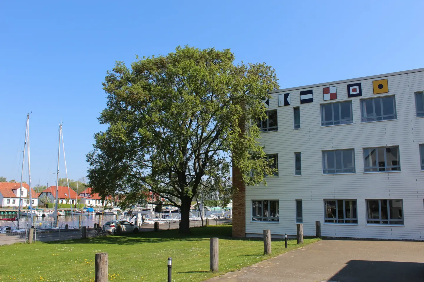 Klassenfahrt Greifswald - Hostel von außen mit Hafen im Hintergrund