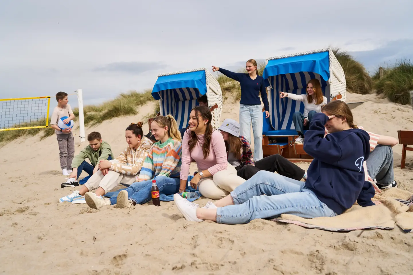 Klassenfahrt Weissenhäuser Strand - Eine Gruppe von Schülern am Strand vor zwei Strandkörben.