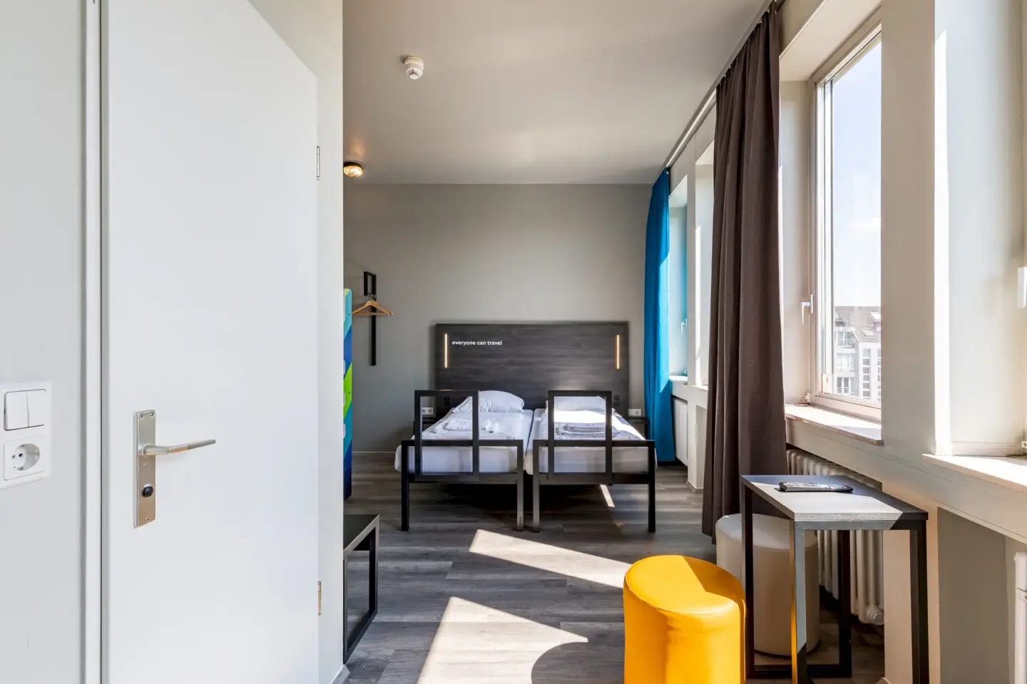 Klassenfahrt Aachen - lichtdurchflutetes Zimmer mit Doppelbett, Tisch und Hocker