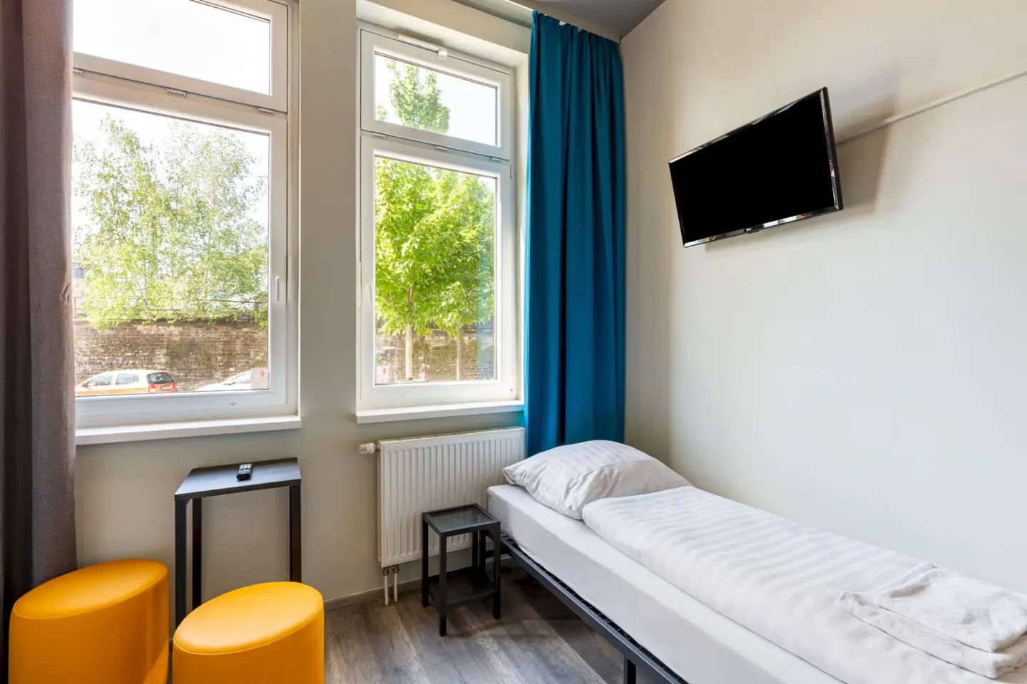 Klassenfahrt Aachen - Einzelzimmer mit einem Bett und TV an der Wand