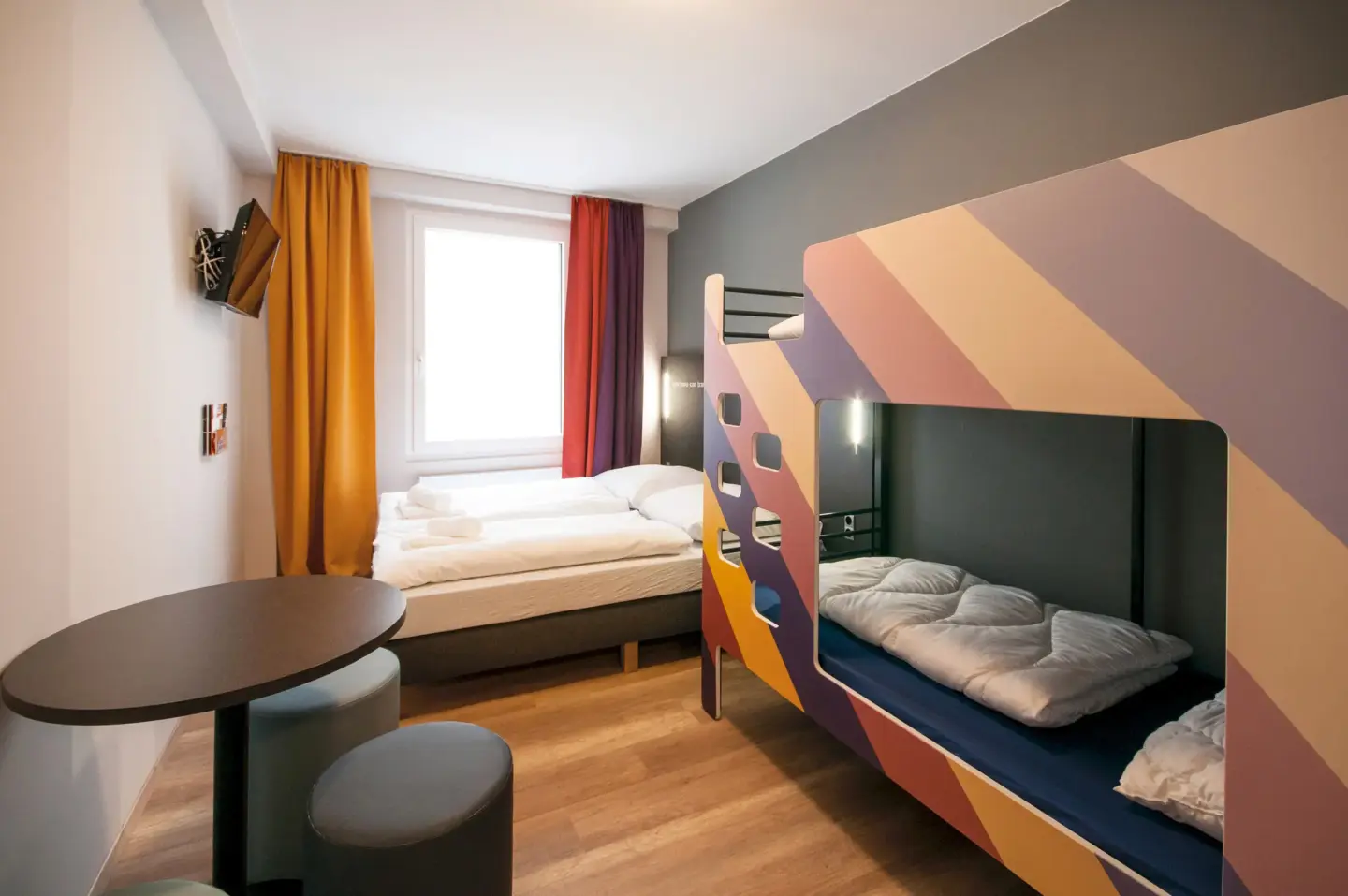 Klassenfahrt Bremen - kleineres Mehrbettzimmer mit einem Doppelstockbett und einem Doppelbett am Fenster
