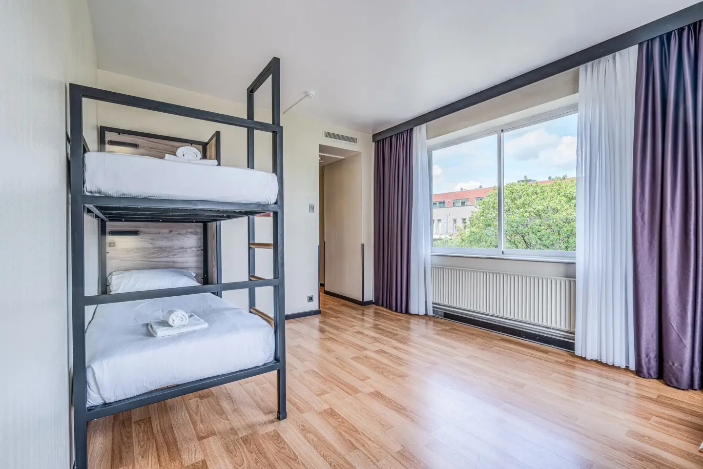 Klassenfahrt Brüssel - Mehrbettzimmer mit Doppelstockbett und lila Vorhängen