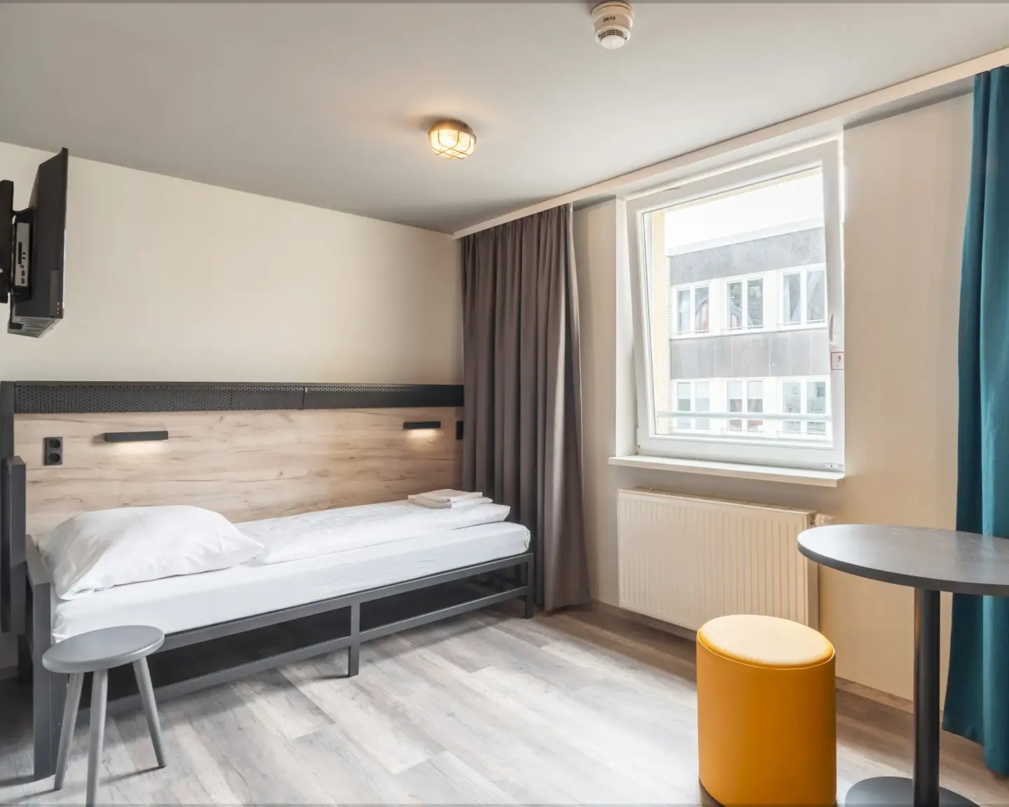Klassenfahrt Köln - helles Einzelzimmer mit Tisch und Hocker