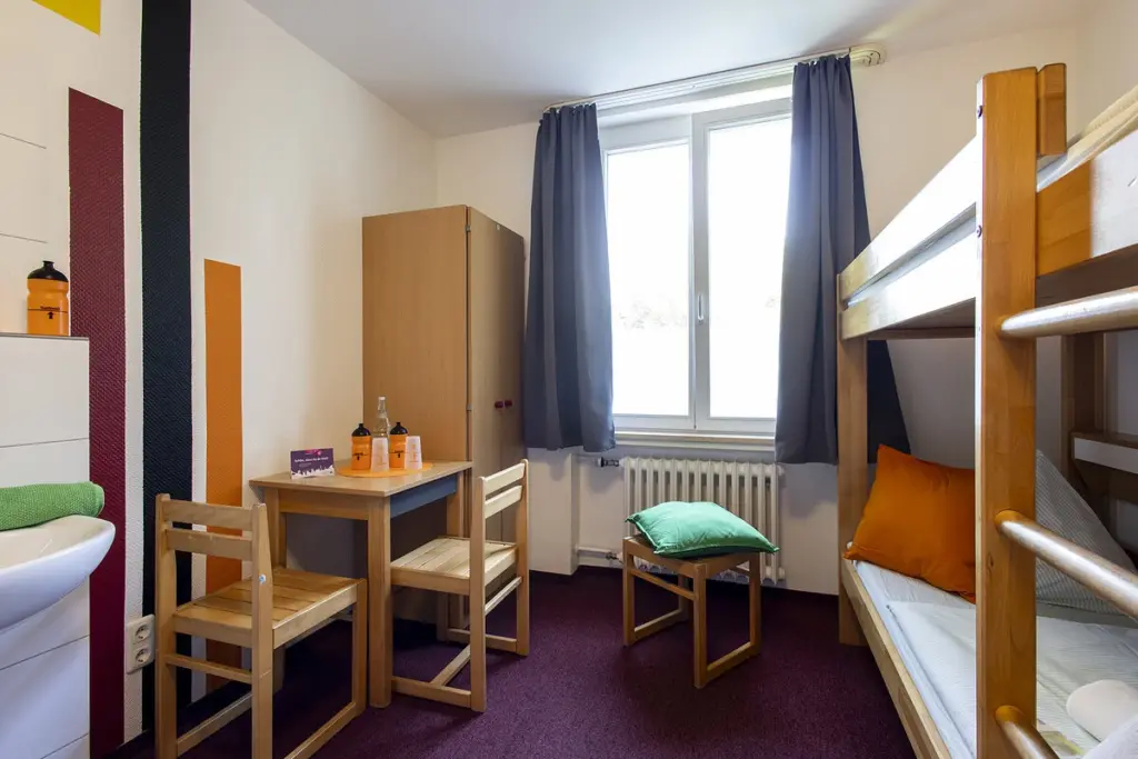 Klassenfahrt Essen - Mehrbettzimmer mit Doppelstockbett, Tisch und Stühlen und Waschecke