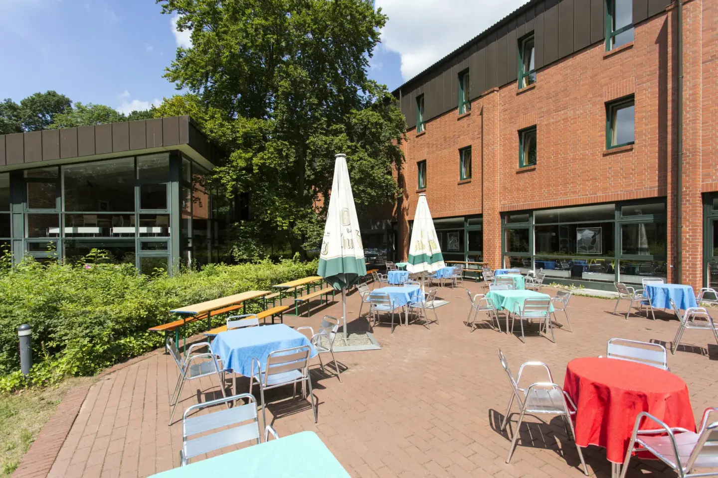 Klassenfahrt Bonn - sonnige Terrasse mit Sonnenschirmen, Tischen und Stühlen