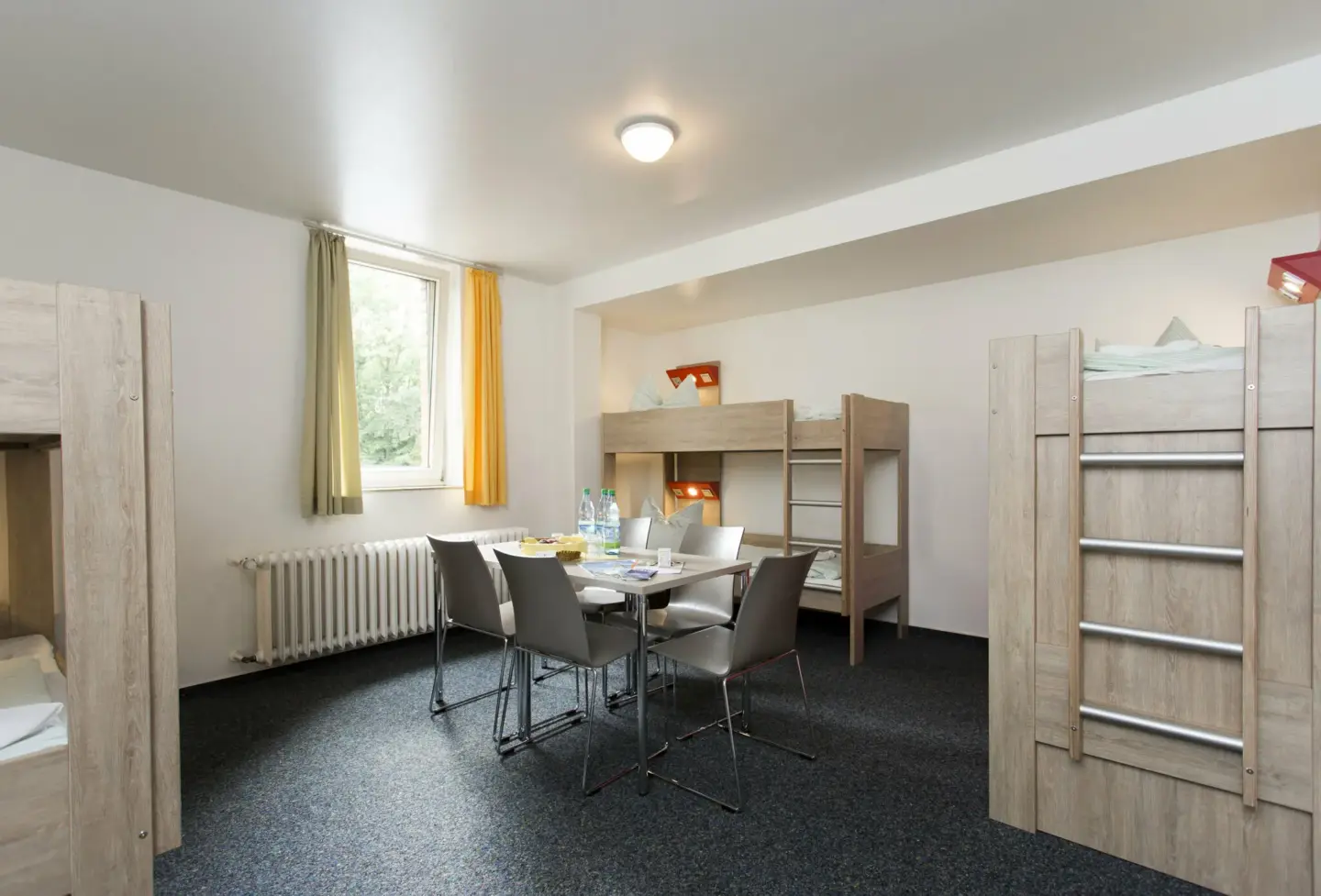 Klassenfahrt Bonn - großes Mehrbettzimmer mit Doppelstockbetten, Fenster, Tisch und Stühlen