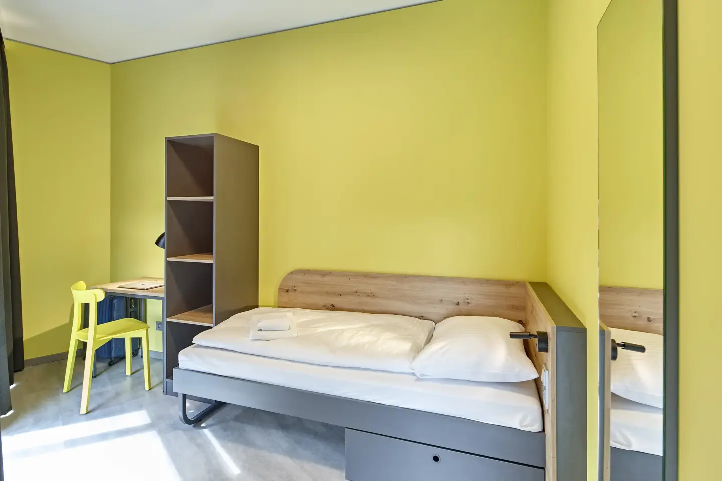 Klassenfahrt Köln - Einzelzimmer mit Tisch und Stuhl und Regal