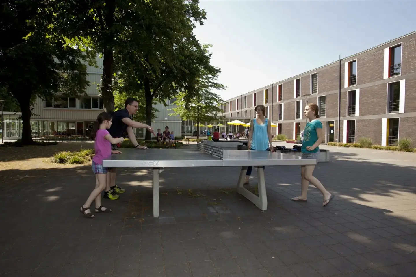 Klassenfahrt Düsseldorf - eine Familie spielt Tischtennis im Außenbereich