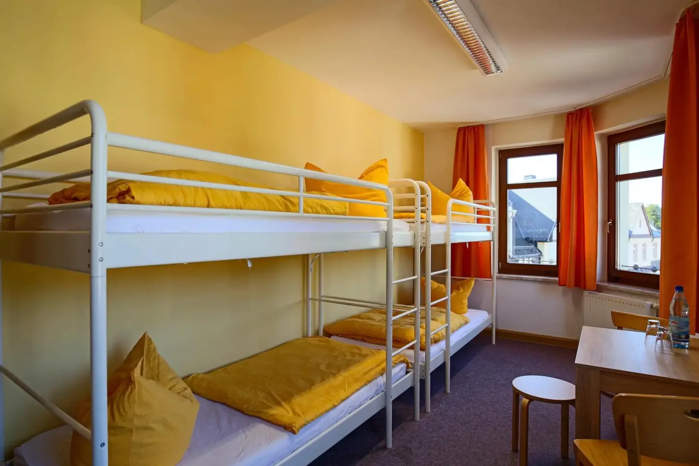 Klassenfahrt Eibenstock - Mehrbettzimmer mit zwei Doppelstockbetten, Tisch und Hocker