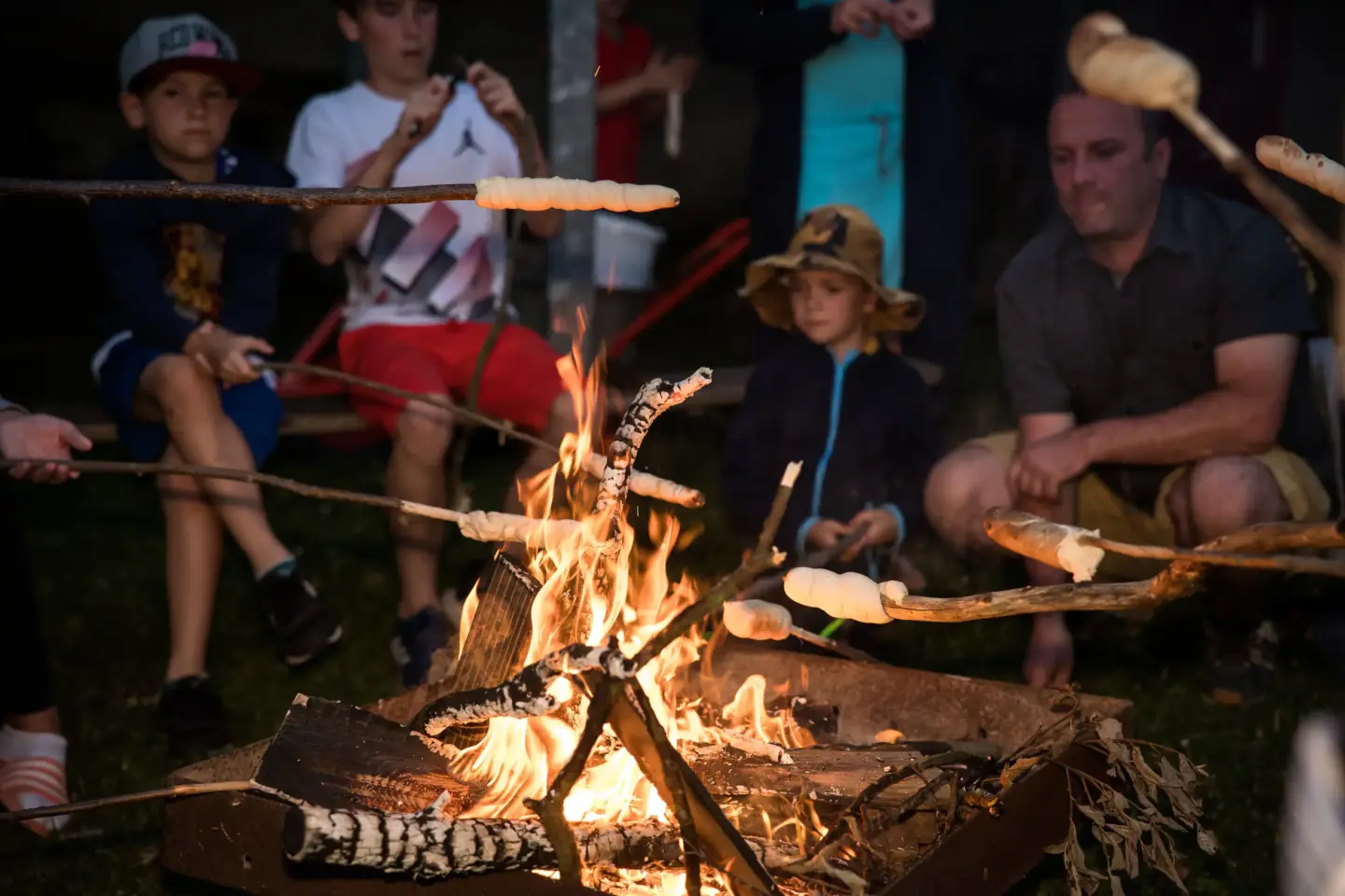 Klassenfahrt Sächsische Schweiz - Personen sitzend am Lagerfeuer mit Stockbrot